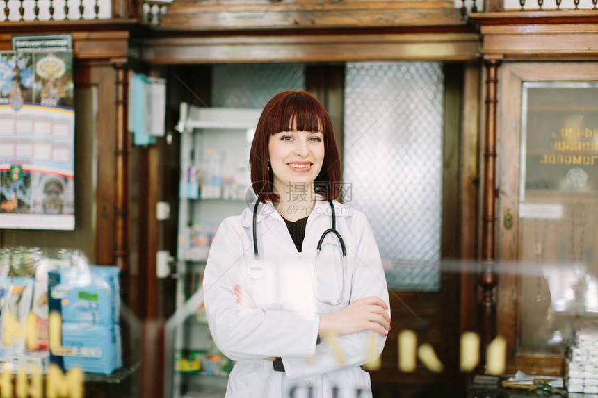 一位美丽的药剂师的横向肖像笑着对摄影机微笑喜悦地在图片