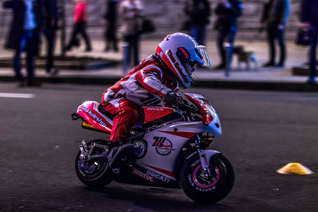 一个骑着玩具摩托车的孩子在街上骑行图片