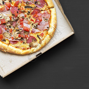 带培根西红柿香肠奶酪和蘑菇的披萨图片