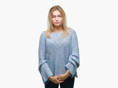 身着冬季毛衣的年轻天主教女青年在孤立的背景上穿着严谨的面部表情图片