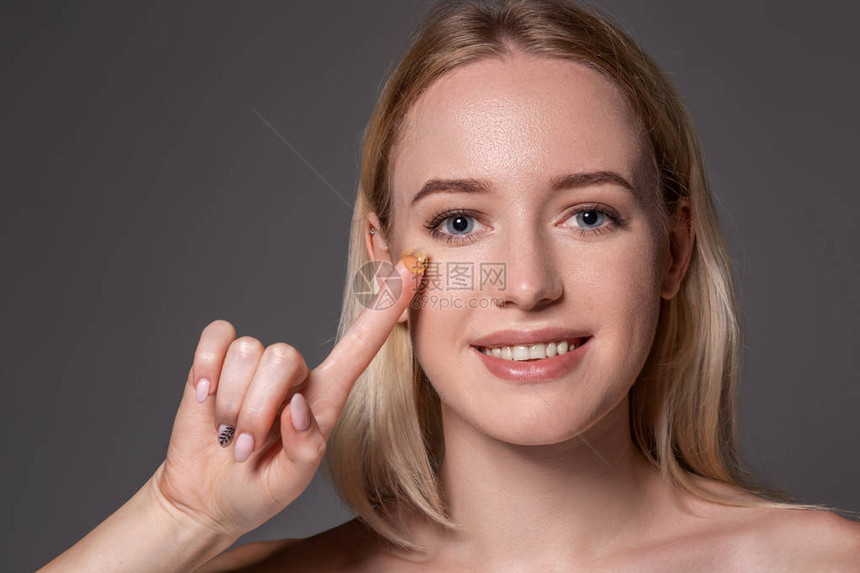 年轻女子在食指上拿着隐形眼镜图片