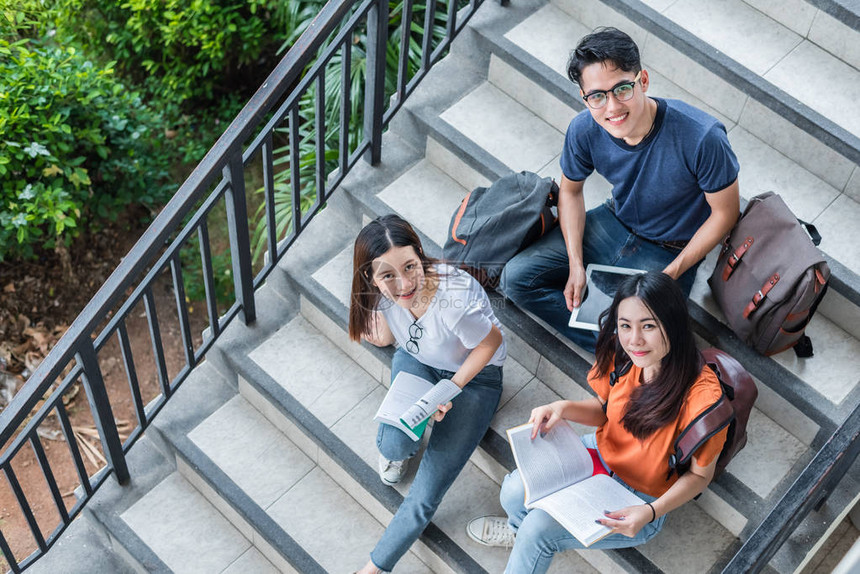 三名亚洲年轻校园学生在图书馆楼梯上一起享受辅导和阅读书籍友谊和教育理念校园学校和大学大学习图片