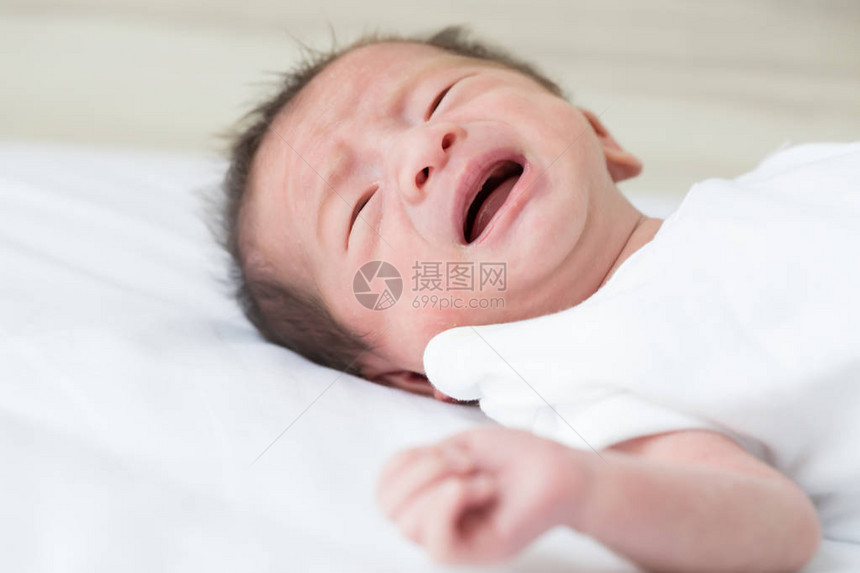 新生婴儿男孩在床上哭泣14天的一生亚图片