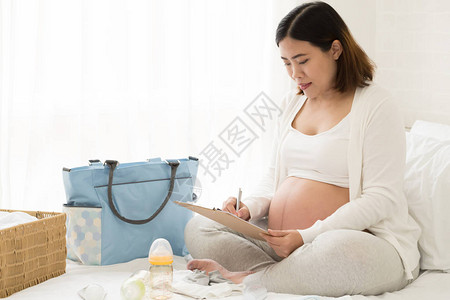 在分娩日期前为8个月的孕妇打包医院包或分娩中心8个月检查图片