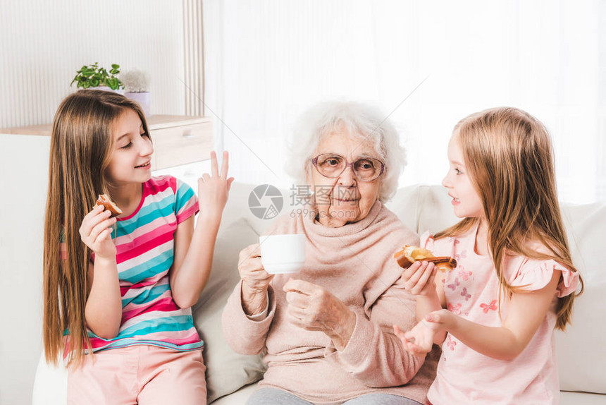 微笑的曾祖母和孙女喝茶图片