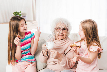 微笑的曾祖母和孙女喝茶图片