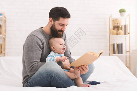 可爱的婴儿与爸共度快乐时光一起阅读图片