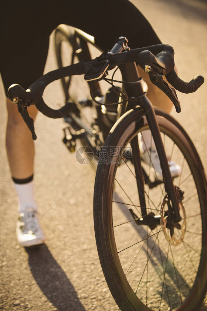 职业公路自行车赛手装扮日落时骑山路图片