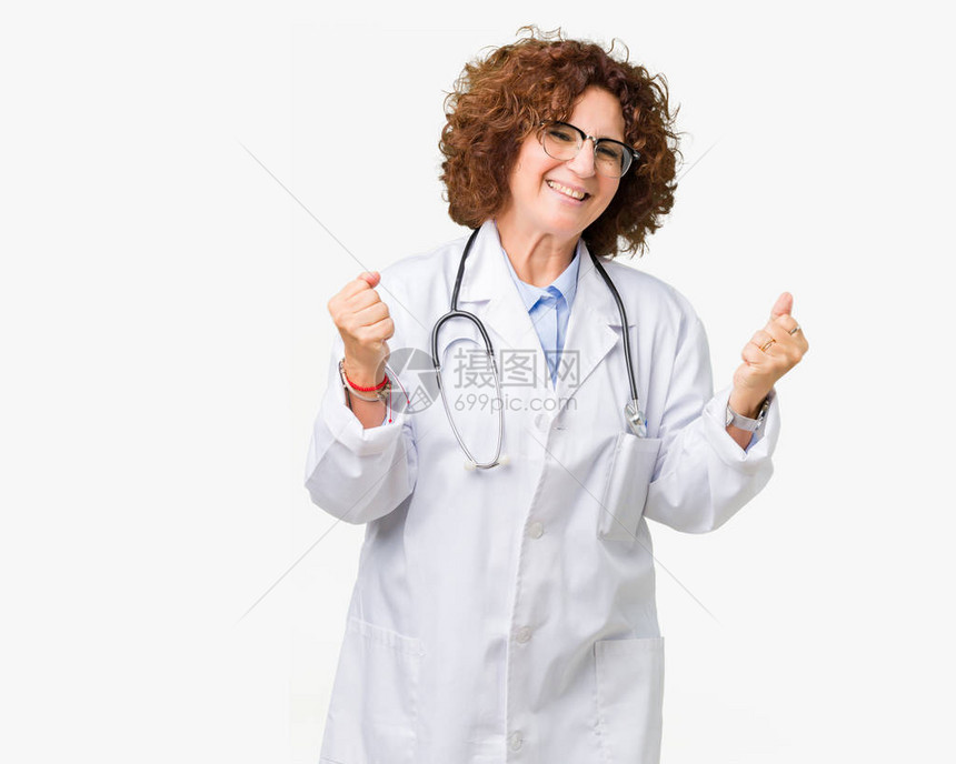 身处孤立背景的中年高级医生女非常快乐和兴奋地以举起手臂微笑和为成功而尖叫的方式做赢家姿态图片
