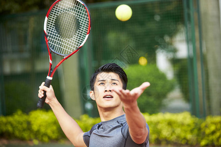 年轻的亚洲成年男子打网球图片