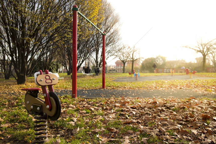 秋天在公园操场的红色摩托车弹簧骑手图片