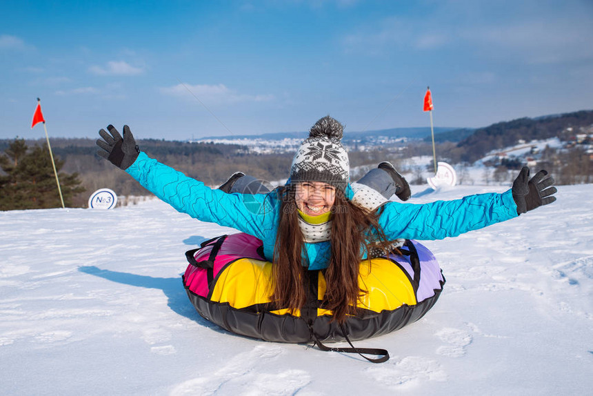 雪油管的年轻漂亮女人举起手来从雪山滑图片