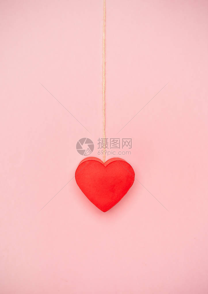 心挂在粉红色背景的一连串绳子上,爱的概图片