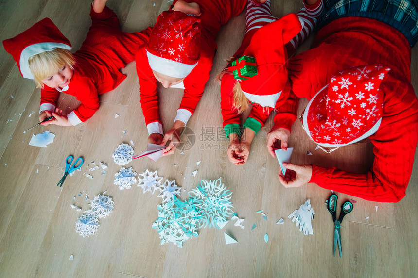 父亲和孩子用纸圣诞手工艺品制作雪花图片