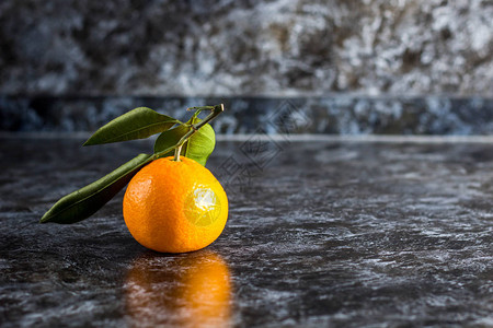 许多橙色的橘子深色背景上有绿叶图片