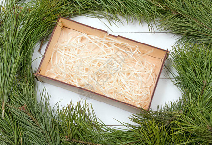 圣诞贺卡和礼品盒冷杉树枝空盒子和木板上的装饰木制背景上的圣诞枞树与图片