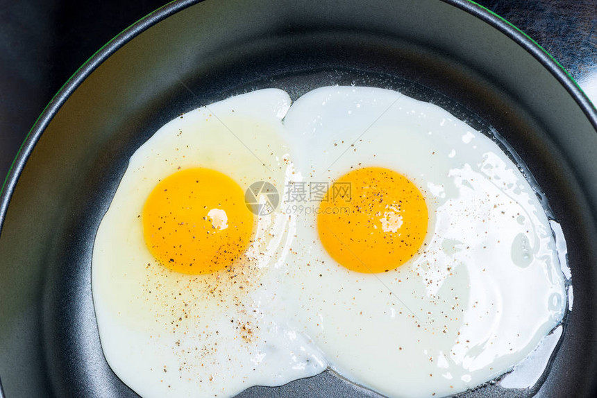 两个鸡蛋的炸鸡蛋在煎锅里炒熟了最顶端视图片