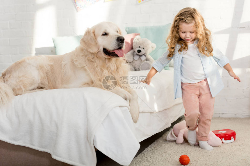 在儿童房间里与狗同在床边站图片