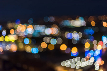 用明亮的圆形散景模糊城市灯光的蓝色夜景图片