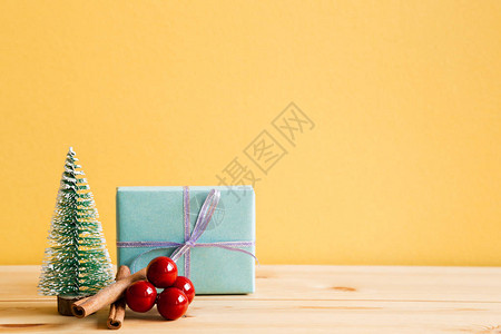 圣诞装饰品礼箱松树黄底木桌图片