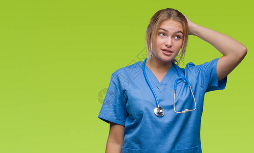 在孤立的背景下穿着外科医生制服的年轻白人医生女人对问题感到困惑和好奇图片