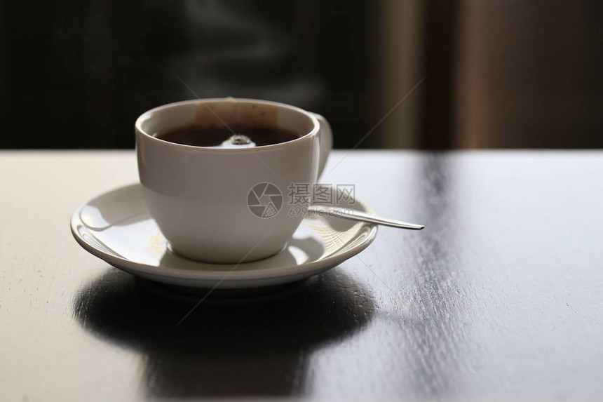 茶袋加勺子和酱汁白陶瓷茶杯放在有黑暗图片