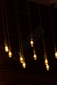 挂在黑色背景上的一组老式发光灯泡的特写镜头餐厅装饰古图片