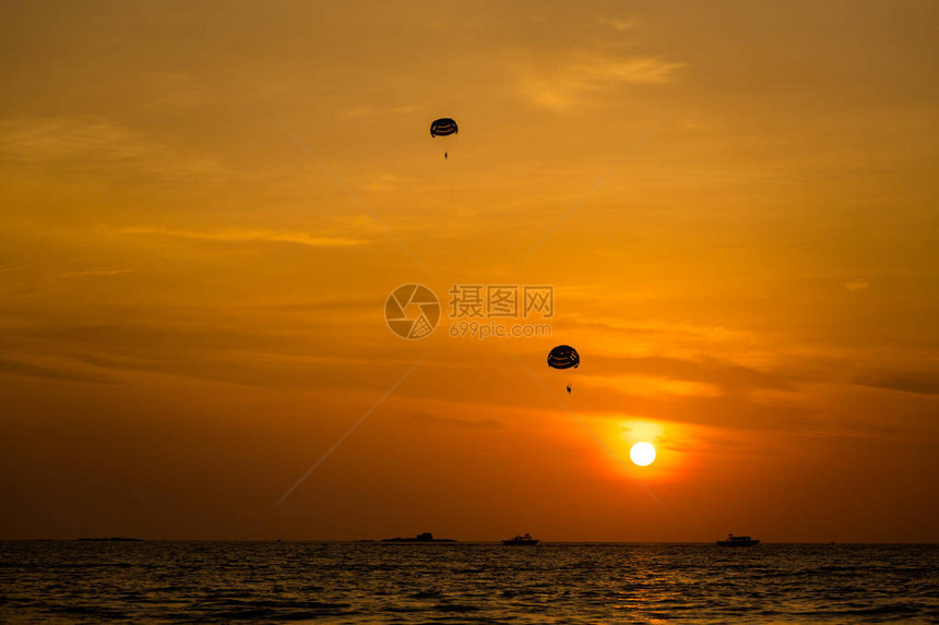 马来西亚热带兰卡维岛PantaiCenang海滩的水上降落伞在多彩的日落期间图片