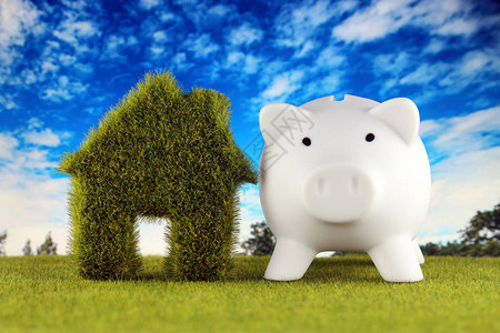 储钱罐和绿色生态房子图标概念与草和蓝天背景可再生能源电背景图片