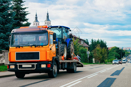 在波兰的公路上载有拖拉机的卡车运货车图片