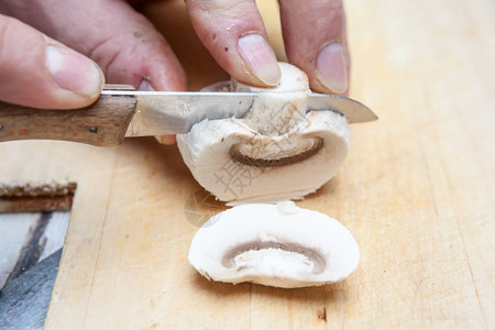 在木板上用土豆刀切蘑菇图片