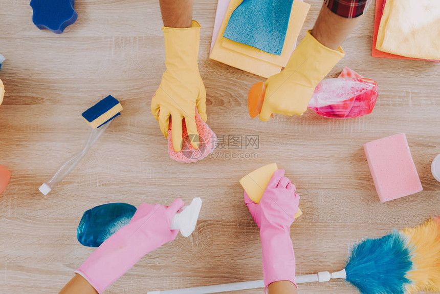 年轻夫妇在格子衬衫清洁室居家卫生手戴橡胶手套家政理念用海绵清洁使用喷雾家庭在家里夫妇室图片