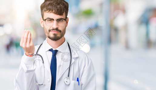 身穿医院外套背景孤立的年轻医生用手和指自信地表图片