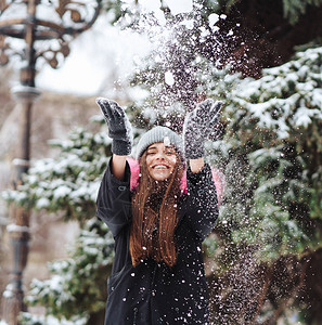 女孩在城里扔雪天气冷图片