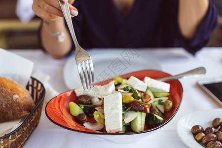 希腊沙拉加奶酪橄榄白辣椒洋葱黄瓜片在美丽的黑面包篮中图片