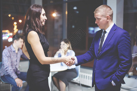 一群年轻的办公室经理庆祝交易成功完成男人与女商人握手团队合作图片