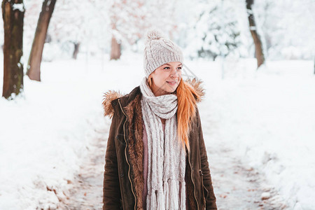 下雪天在公园散步的年轻女子图片