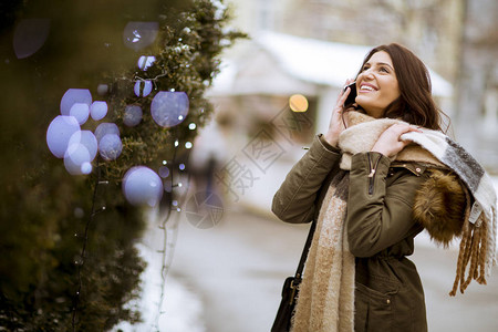 在冬季户外用手机描绘微笑的年图片