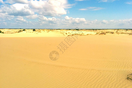 干旱沙漠景观中多云天空下的孤独沙丘图片