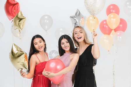 年轻快乐女多样在聚会白背景和多彩的节日气球上一图片