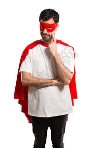 面罩和红色斗篷的超级英雄男子站立并仰望前方图片