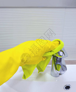 清洁者手用黄色手套洗浴盆的毛巾擦拭水龙头图片