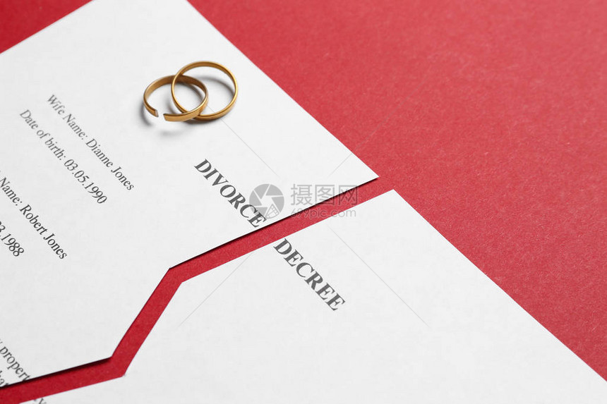 撕裂的离婚法令与彩色背景上的戒指图片