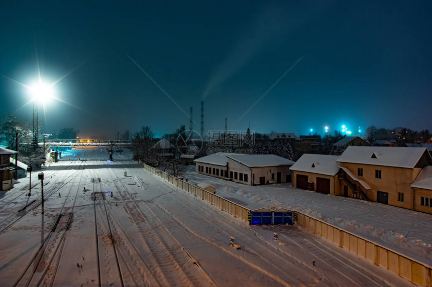 夜间降雪期间城市的铁路轨道图片