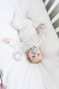 婴儿在婴儿床里有奶嘴的图片