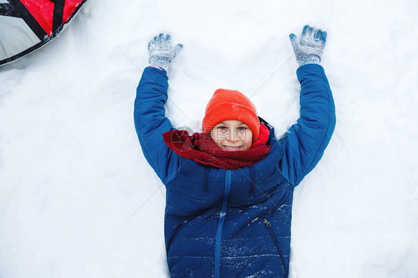 穿着蓝色帽子的可爱小男孩拿着雪玩图片