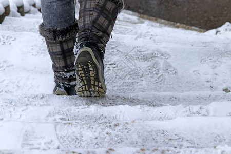 一个女人在冬天走下楼梯冬天在积雪的楼梯上图片