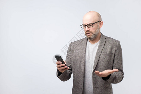 穿着西装戴着眼镜阅读短信的不满意脾气暴躁的男人图片