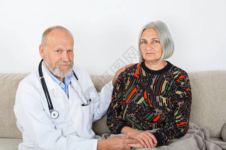 老年男医生检查坐在沙发上的老年妇女图片
