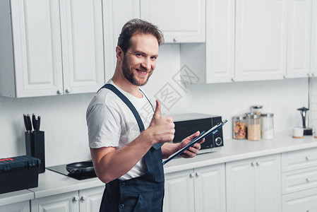 带着剪贴板和在厨房做大拇指举手势的长着微笑的成图片